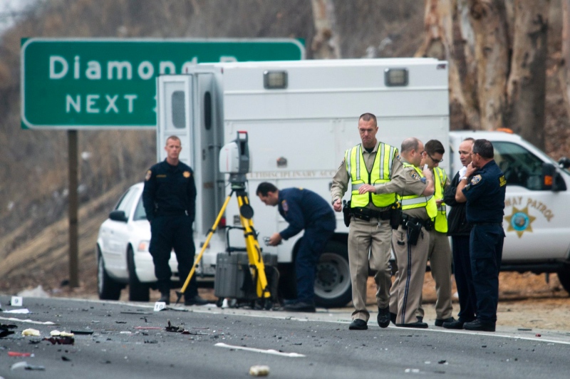 Officials investigate the scene of a multiple vehicle accident where six people were killed on the westbound Pomona Freeway in Diamond Bar, Calif., on Sunday morning, Feb. 9, 2014. (AP / San Gabriel Valley Tribune,Watchara Phomicinda)