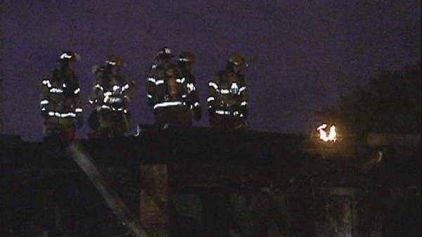 Firefighters on the roof of a Pointe Claire townhouse that was damaged when fire started in a bedroom (Sept. 12, 2011)