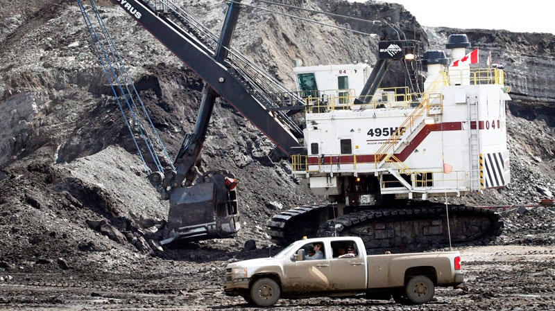 A pickup truck passes a mining shovel at an oil sands mine near Fort McMurray, Alta., in this July 9, 2008 photo. THE CANADIAN PRESS/Jeff McIntosh