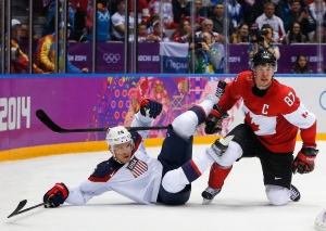 USA forward Paul Stastny trips over Canada forward Sidney Crosby during the second period of a men's semifinal ice hockey game at the 2014 Winter Olympics in Sochi, Russia, Friday, Feb. 21, 2014. (AP / Petr David Josek)