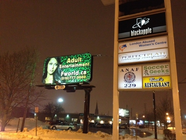 A billboard advertising adult entertainment is seen next to the new London Abused Women's Centre location in London, Ont. on Thursday, Feb. 20, 2014. (Celine Moreau / CTV London)