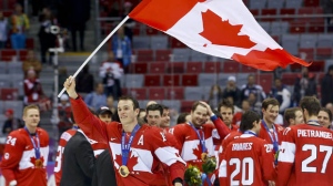 Canada forward Jonathan Toews waves the Canadian flag after Canada beat Sweden 3-0 in the men's gold medal ice hockey game at the 2014 Winter Olympics, Sunday, Feb. 23, 2014, in Sochi, Russia. (AP Photo/Matt Slocum)