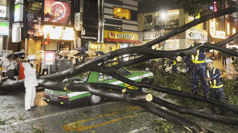 The rear section of a taxi is crushed by a fallen tree in Tokyo on Wednesday Sept. 21, 2011 as powerful Typhoon Roke barreled across central Japan with heavy rains and sustained winds of up to 100 mph (162 kph). (AP / Kyodo News)