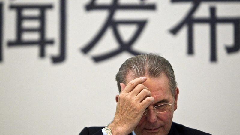 Jacques Rogge, president of International Olympic Committee, rubs his forehead during a press conference in Beijing, China, Friday, Sept. 23, 2011. (AP Photo/Alexander F. Yuan)