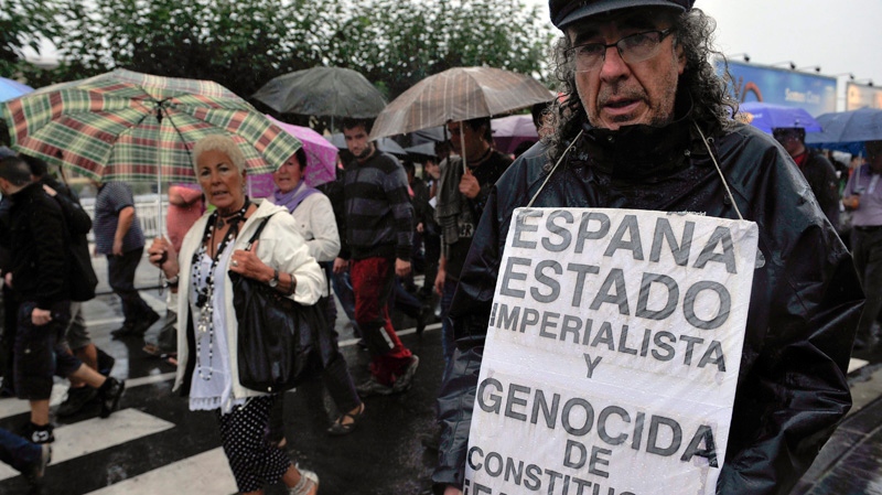 A man displays a banner reading, ' Spain, Imperialist State and Genocide. Fascist Constitution ' during a rally calling for the freedom of top Basque independence leader, Arnalod Otegi, in San Sebastian, northern Spain, Saturday Sept.17, 2011. A Spanish court found a prominent Basque separatist guilty of terrorism yesterday, Friday, and sentenced him to 10 years in prison for trying to resurrect the banned political wing of the militant group ETA. (AP Photo/Alvaro Barrientos). 