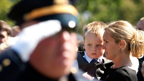 An officer salutes in front of Christine Russell, wife of fallen Toronto police Sgt. Ryan Russell, at a Police and Peace Officers' National Memorial DAy event in Ottawa, Ont. Sept. 25, 2011. ( THE CANADIAN PRESS/Fred Chartrand)