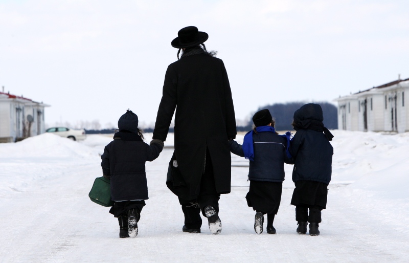 Members of the Lev Tahor ultra-orthodox Jewish sect walk down a street in Chatham, Ont., on Wednesday, March 5, 2014. (The Canadian Press/Dave Chidley)