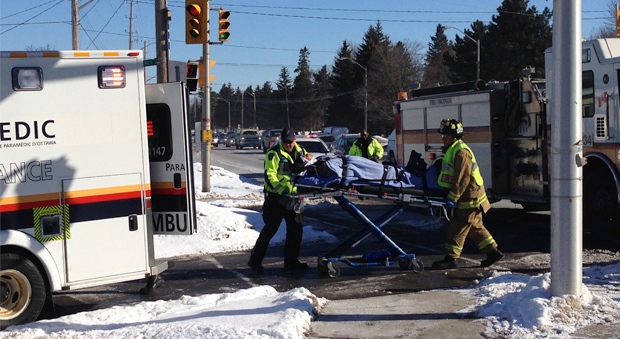 A female pedestrian is being brought to her ambulance after being struck by a vehicle on Riverside Dr., Thursday morning. (Tyler Fleming/CTV Ottawa)