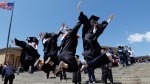 Graduating students from Temple University jump for a photo in Philadelphia. (AP / Alex Brandon)