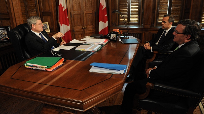 Prime Minister Stephen Harper speaks with Finance Minister Jim Flaherty and Bank of Canada Governor Mark Carney during a meeting in his office on Parliament Hill in Ottawa on Tuesday, Sept. 27, 2011. (Sean Kilpatrick /  THE CANADIAN PRESS)