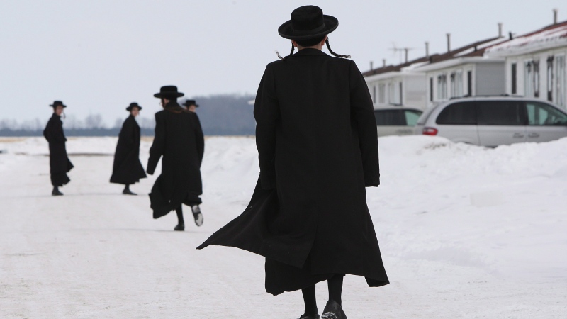 Members of the Lev Tahor ultra-orthodox Jewish sect walk down a street while an emergency motion in the child custody case is held at the courthouse in Chatham, Ont., Wednesday, March 5, 2014. (THE CANADIAN / Dave Chidley)