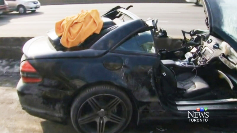 A smashed Mercedes-Benz sits on the side of Highway 401 in Toronto on Monday, March 10, 2014.