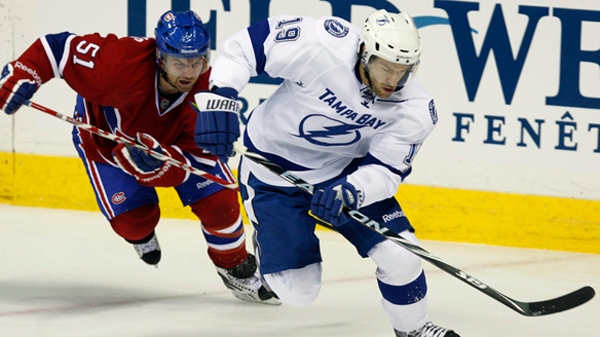 Montreal Canadiens' David Desharnais, left, chases Tampa Bay Lightning's Dominic Moore during first period NHL pre-season action Saturday, October 1, 2011 at the Colisee in Quebec City. THE CANADIAN PRESS/Jacques Boissinot
