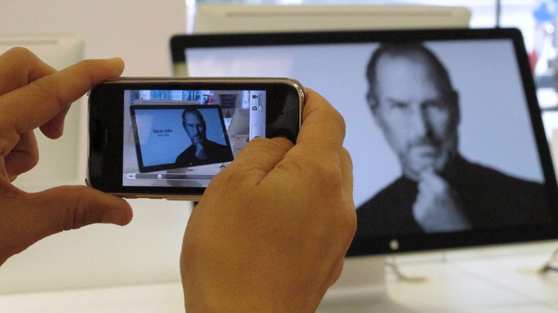 A person takes a photograph with an iPhone of an In Memoriam photo of Steve Jobs, who founded and ran Apple, on display in an Apple store in Prague, Czech Republic, Thursday Oct. 6, 2011. (AP / Selcan Hacaoglu)