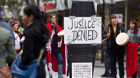 Women sing traditional songs around a mock casket outside the missing women inquiry in downtown Vancouver, Tuesday, Oct. 11, 2011. Commissioner Wally Oppal has opened hearings to examine why police failed to stop Robert Pickton as he murdered impoverished sex workers from Vancouver's Downtown Eastside. THE CANADIAN PRESS/Jonathan Hayward