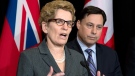 Ontario Premier Kathleen Wynne (left) speaks and Minister of Training, Colleges and Universities Brad Duguid listens at Queen's Park in Toronto, Thursday, March 27, 2014. (Frank Gunn / THE CANADIAN PRESS)