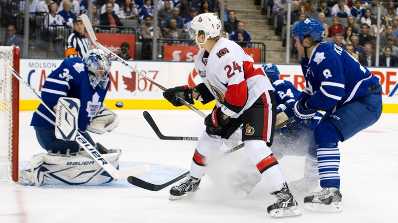 Toronto Maple Leafs goaltender James Reimer ,left, makes a save on Ottawa Senators' Stephane Da Costa ,center left, as Leafs' John-Michael Liles, center right, and Mike Komisarek defend during first period NHL hockey action in Toronto on Saturday Oct. 8, 2011. Da Costa is looking to be an impact player for the Ottawa Senators, but so far he's been on the receiving end of some serious contact. THE CANADIAN PRESS/Chris Young