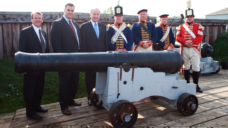 Minister James Moore, Minister Rob Nicholson, Alan Latourelle, CEO of Parks Canada, and honourary guards are behind cannon at Fort George on Tuesday, Oct. 11, 2011.