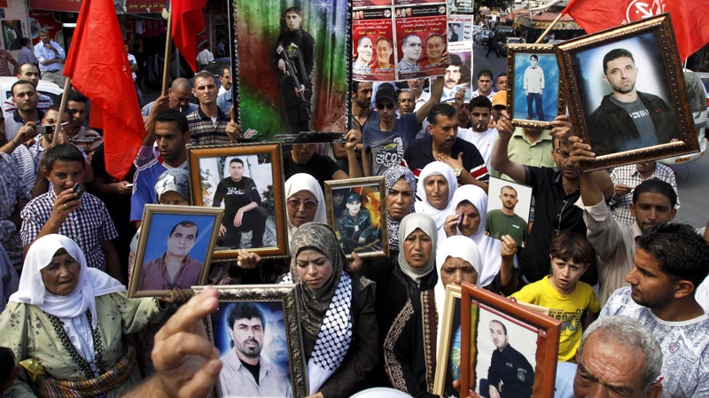 Palestinians demonstrate in solidarity with prisoners jailed in Israel in the West Bank city of Jenin, Thursday, Oct. 13, 2011. (AP / Mohammed Ballas)
