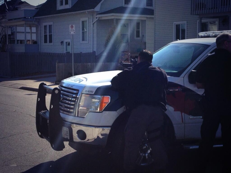 Windsor police officers are seen outside of a Pierre Avenue home with guns drawn -- demanding the surrender of a man inside on Wednesday, April 2, 2014. (Sacha Long/ CTV Windsor)