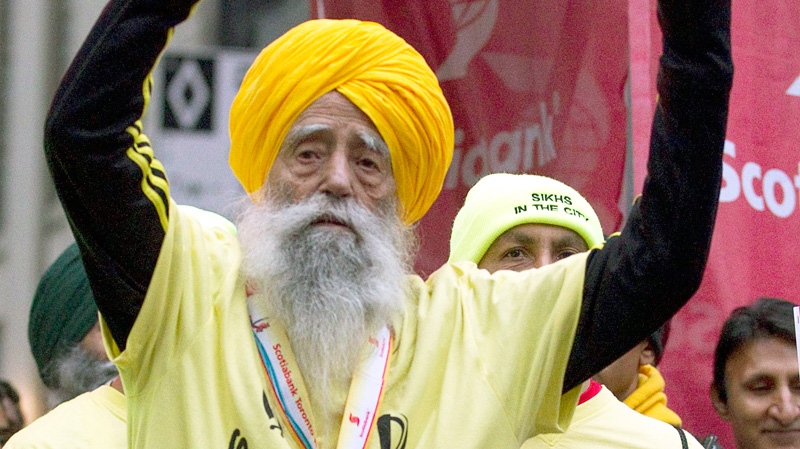 Fauja Singh, aged 100, celebrates after crossing the line in the Toronto Waterfront Marathon in Toronto on Sunday, Oct. 16, 2011. (Frank Gunn / THE CANADIAN PRESS)