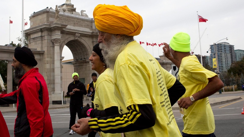One-hundred-year-old Fauja Singh (centre) takes part in the Toronto Waterfront marathon on Sunday, Oct. 16, 2011. (Chris Young / THE CANADIAN PRESS)