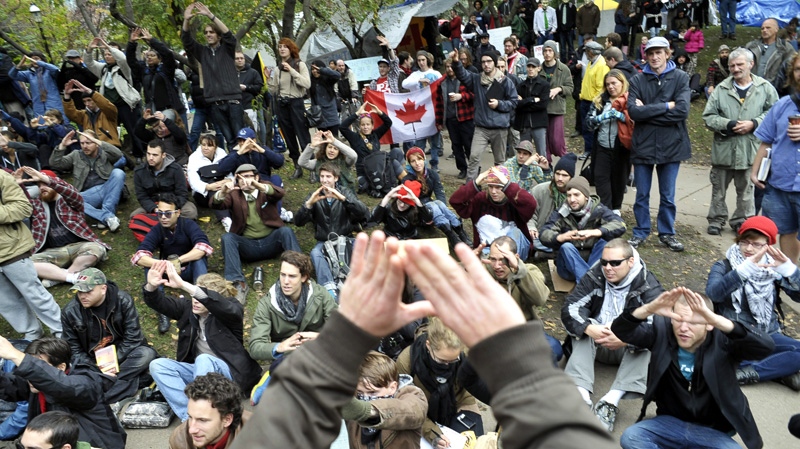 Protesters practise communication hand signals in a staging area at a downtown church grounds in Toronto, Sunday, Oct. 16, 2011. (J.P. Moczulski / THE CANADIAN PRESS)
