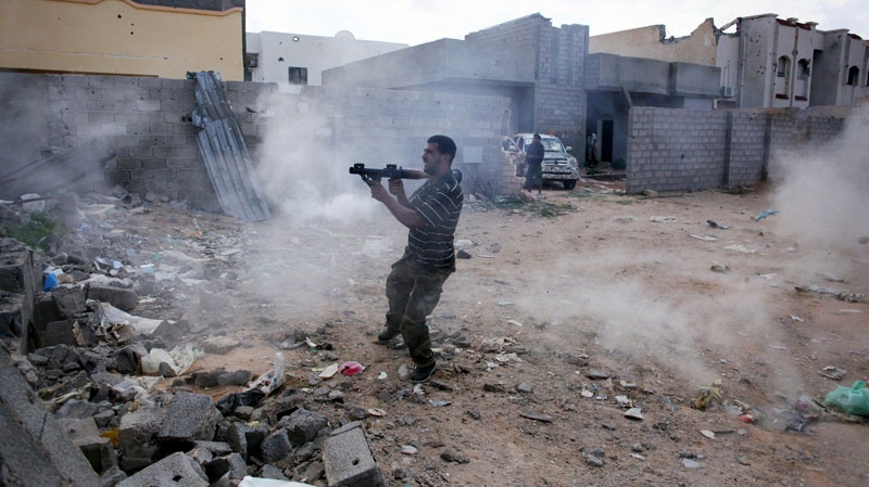 A revolutionary fighter fires a rocket-propelled grenade at Gadhafi loyalist positions in downtown Sirte, Libya, Tuesday, Oct. 18, 2011. (AP / Manu Brabo)