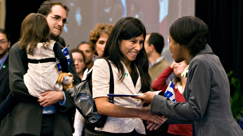 Quebec Immigration Minister Yolande James, right, gives a certificate to Nana Jacqueline Samaniego Sayritupac as her husband Hugo Savard and their child looks on at a newcomers welcoming ceremony Monday, Oct. 22, 2007 at the Quebec legislature. (Jacques Boissinot / 