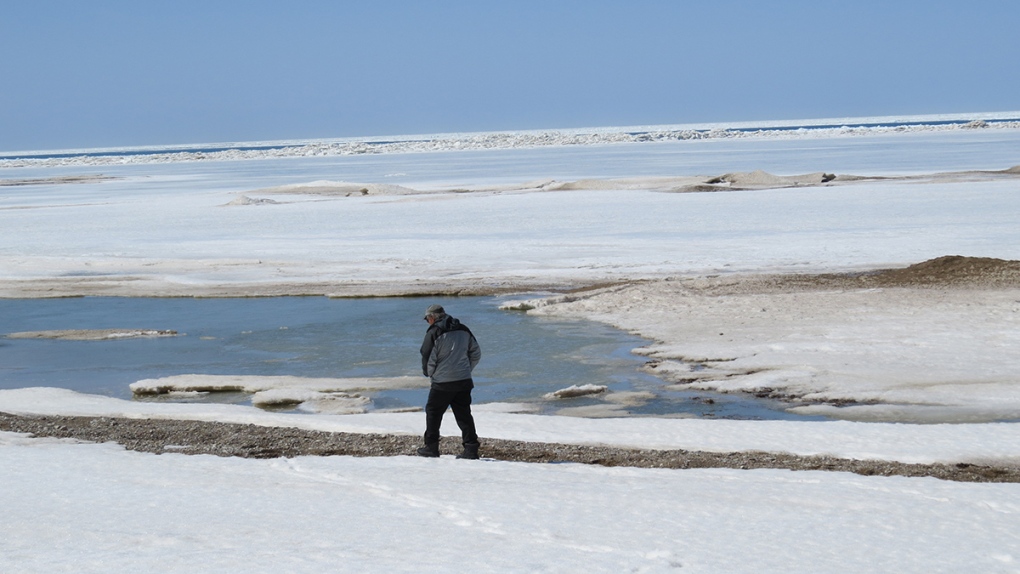  man walks near ice-covered Lake Huron