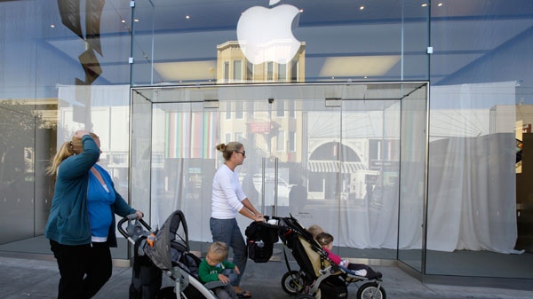 Two women walk with children past a curtained Apple store in the Marina district in San Francisco, Wednesday, Oct. 19, 2011. (AP / Eric Risberg)