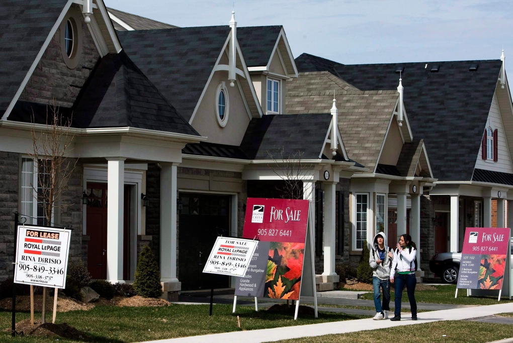 People walk past new homes in Oakville