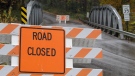 A road closed sign leading into the Muskingum County Animal Farm is shown Wednesday, Oct. 19, 2011, in Zanesville, Ohio. Police with assault rifles stalked a mountain lion, grizzly bear and monkey still on the loose after authorities said their owner apparently freed dozens of wild animals and then killed himself. (AP / Tony Dejak)