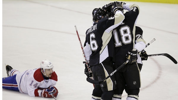 Pittsburgh Penguins' James Neal (18) celebrates with teammates after scoring a first-period goal as Montreal Canadiens' Tomas Plekanec (14) watches during an NHL hockey game Thursday, Oct. 20, 2011, in Pittsburgh. (AP Photo/Gene J. Puskar)