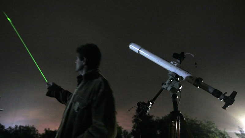 An astronomer uses a laser pointer to show the radiant of the Orionids at an observatory east of the Bulgarian capital Sofia, in this Oct. 20, 2009 file photo. (AP Photo/Petar Petrov)