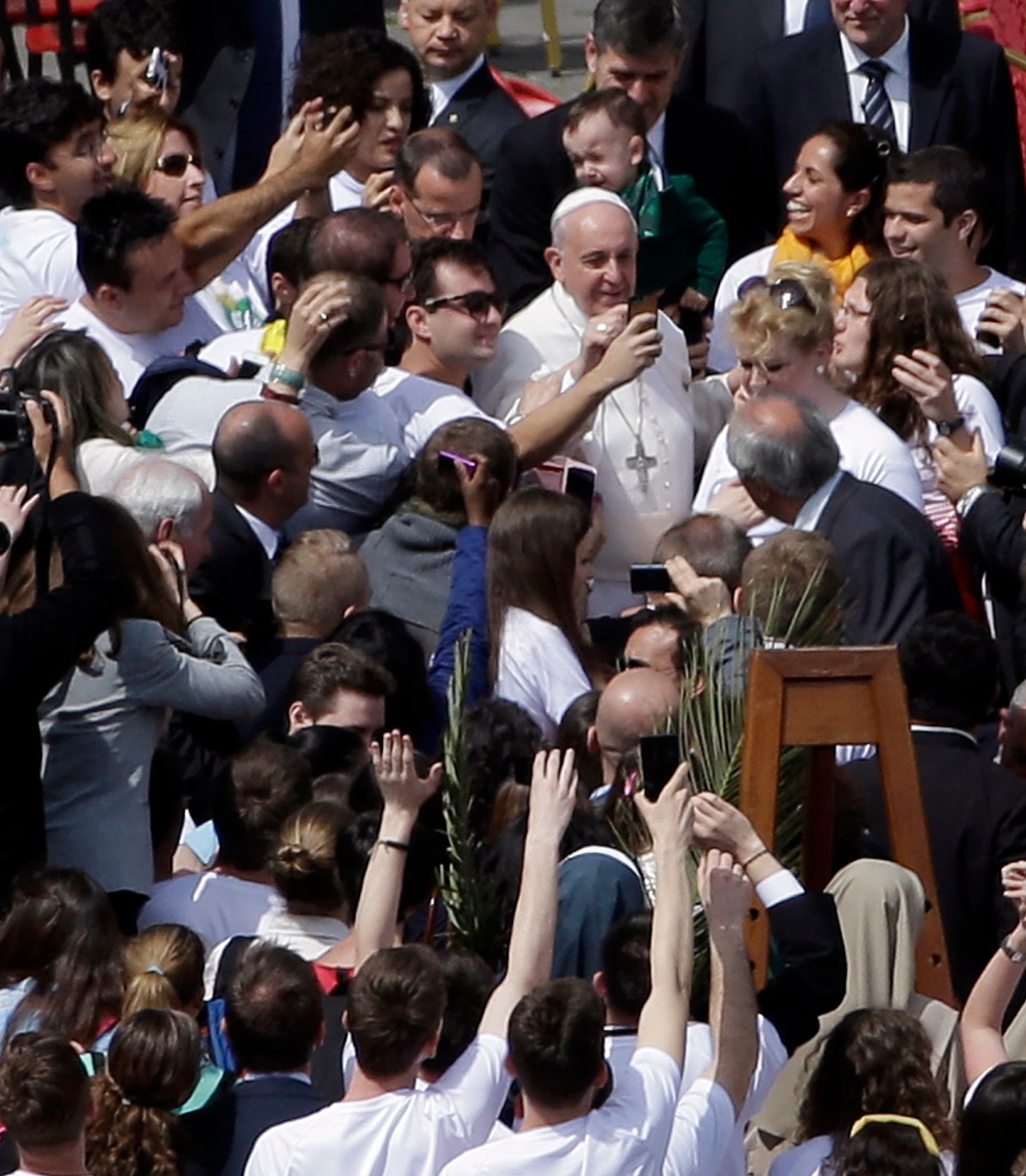 Pope Francis poses for pictures with faithful