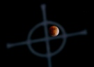 A lunar eclipse is framed in a church's steeple cross just west of Ottawa on Feb. 20, 2008. (Sean Kilpatrick/THE CANADIAN PRESS)