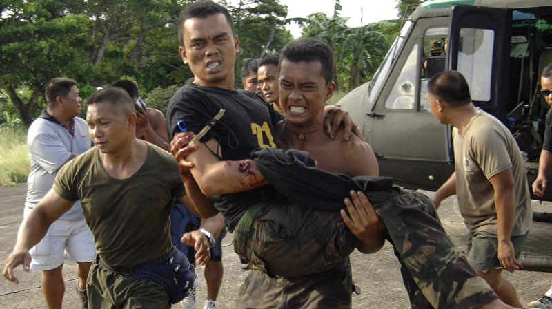 A soldier carries a wounded trooper from Basilan province as they land at the southern port city of Zamboanga, Philippines Tuesday, Oct. 18, 2011. Philippine troops are battling Muslim guerrillas in fierce fighting in volatile Basilan province that has killed at least 15 combatants. (AP Photo)