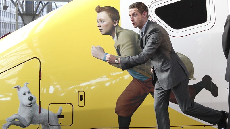 British actor Jamie Bell poses next to Belgian cartoon hero Tintin, depicted on a special high speed Thalys train boarding for Paris in Brussels, Saturday, Oct. 22, 2011. (AP Photo/Yves Logghe)