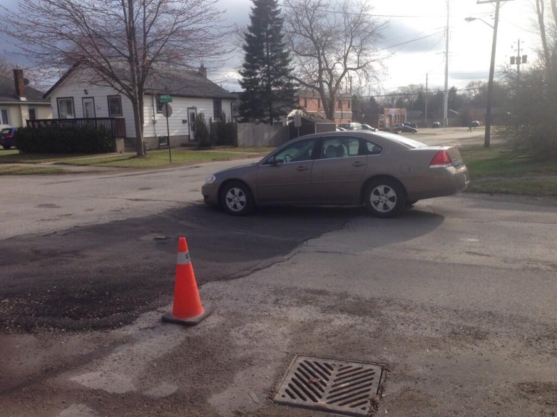 A car navigates over a pothole on Vancouver Street, south of Dundas, in London, Ont. on Monday, April 14, 2014. (Gerry Dewan / CTV London)