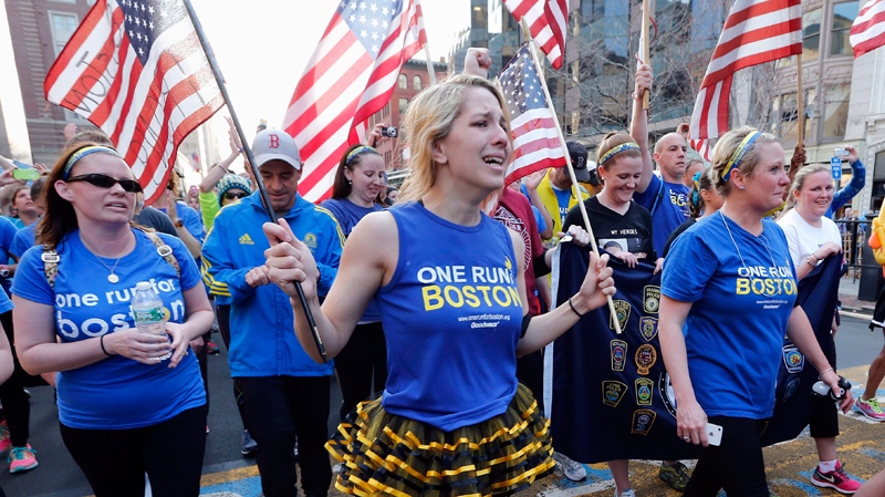 Participants in a cross country charity relay that began in March in California cross the finish line of the Boston Marathon in Boston, Sunday, April 13, 2014. (AP Photo/Michael Dwyer)