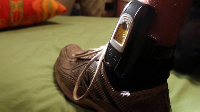Parole Agent Steve Nakamura inspects a GPS locater worn on the ankle of a parolee in Rio Linda, Calif. on Aug. 3, 2009. (AP Photo / Rich Pedroncelli)
