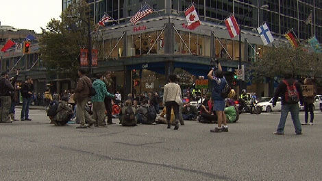 Occupy Vancouver protesters sit in the street at Georgia and Burrard streets. Oct. 22, 2011. (CTV)