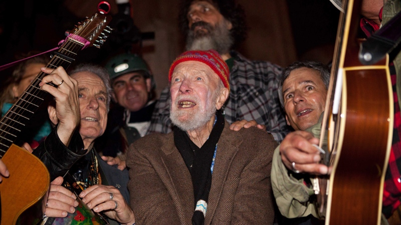 Activist musician Pete Seeger, 92, center, sings before a crowd of nearly a thousand demonstrators sympathetic to the Occupy Wall Street protests at a brief acoustic concert in Columbus Circle, Saturday, Oct. 22, 2011, in New York. (AP Photo/John Minchillo)