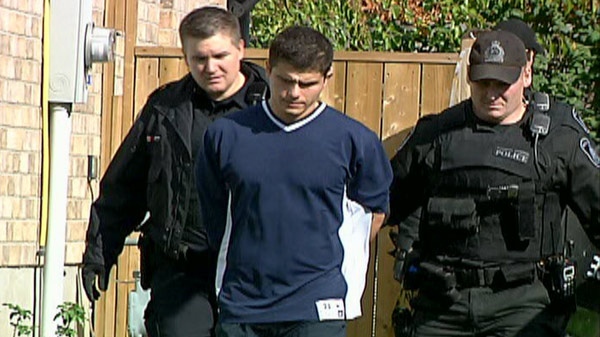 Twenty-three-year-old Nikola Popic, center, is arrested at his Copper Leaf Street home in Kitchener, Ont. on Monday, Oct. 24, 2011.