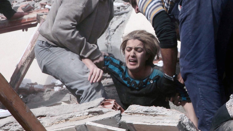People rescue a woman trapped under debris after a powerful 7.2-magnitude earthquake struck eastern Turkey, collapsing about 45 buildings in Van province, Sunday, Oct. 23, 2011 according to the deputy Turkish prime minister. ( AP Photo/ Ali Ihsan Ozturk, Aatolia)