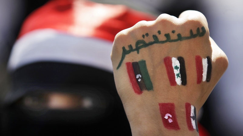 A Yemeni female protestor shows her hand with Arabic that reads 'we will prevail' and the colors of pre-Gadhafi Libya, Syria, Yemen, Tunisia and Egypt during a demonstration demanding the resignation of Yemeni President Ali Abdullah Saleh in Sanaa, Yemen, Wednesday, Oct. 26, 2011. (AP / Hani Mohammed)