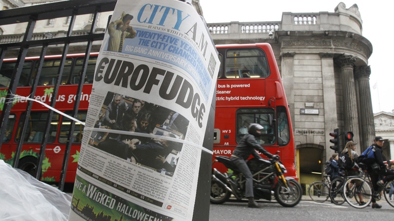 A financial newspaper is fixed to a pillar by a newspaper seller with The Bank of England building behind, in the city of London, Thursday, Oct. 27, 2011. (AP Photo/Kirsty Wigglesworth)