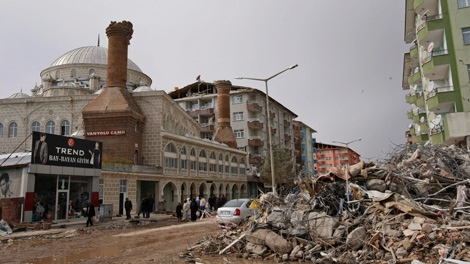 Rubble is seen in a main road in front of the damaged minarets of a mosque in the city center of Ercis, Turkey, Saturday, Oct. 29, 2011. (AP / Burhan Ozbilici))