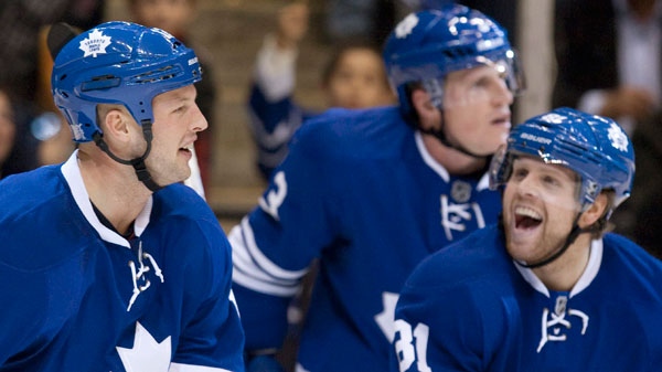 Toronto Maple Leafs' Tim Connolly (left) is congratulated by Phil Kessel (right) after scoring his team's second goal against Pittsburgh Penguins as Maple Leafs' Dion Phaneuf (centre) skates by during second period NHL hockey action in Toronto on Saturday October 29, 2011. (Chris Young / THE CANADIAN PRESS)